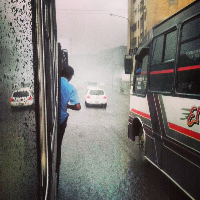 Camionetica en un día lluvioso con pasajero en la puerta. Foto @victor_53